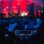 a stage with a laptop and microphone in front of a crowd